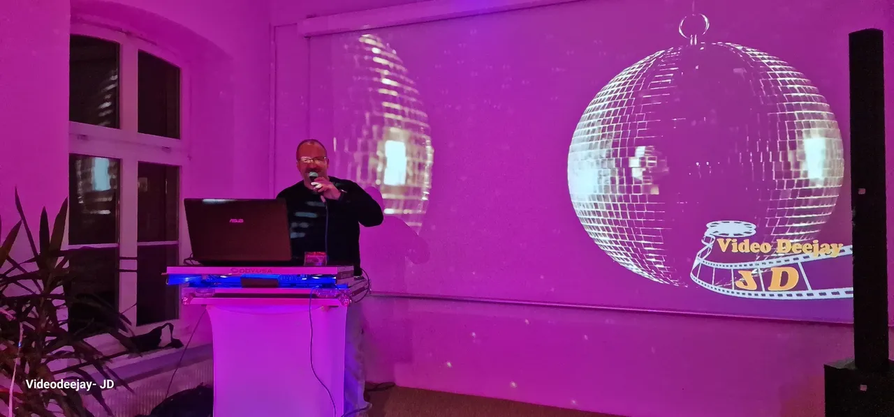 Video: Auftritt von DJ JD auf einer Party mit Discokugelprojektion.